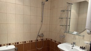 Un baño con inodoro, lavamanos y ducha.