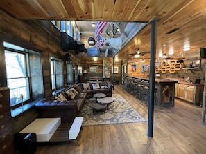 Un intérieur rustique avec un canapé en cuir, des planchers en bois et un coin bar.