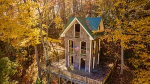 A house on stilts surrounded by autumn foliage.