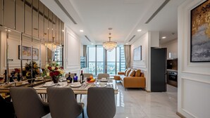 Un espace de salle à manger moderne, doté d’une grande table, de chaises et d’un lustre.