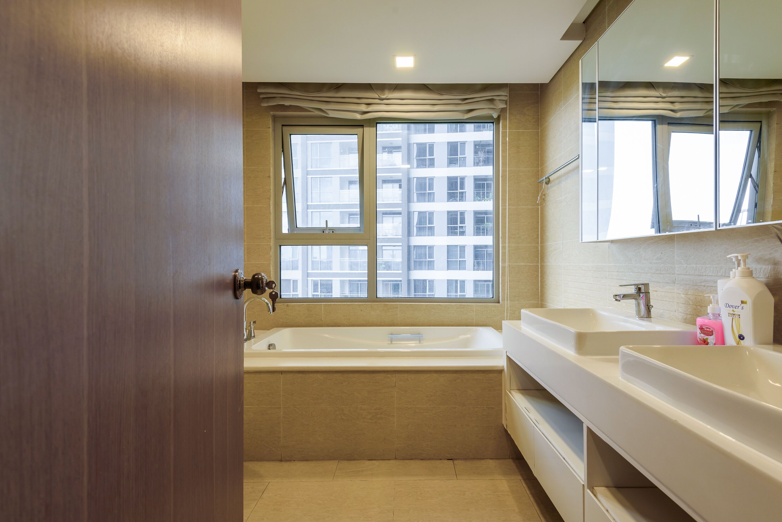 Une salle de bain moderne avec une baignoire, deux lavabos et un grand miroir.