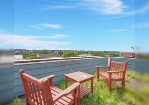 Une terrasse sur le toit offrant une vue sur le paysage urbain, avec une table et deux chaises.