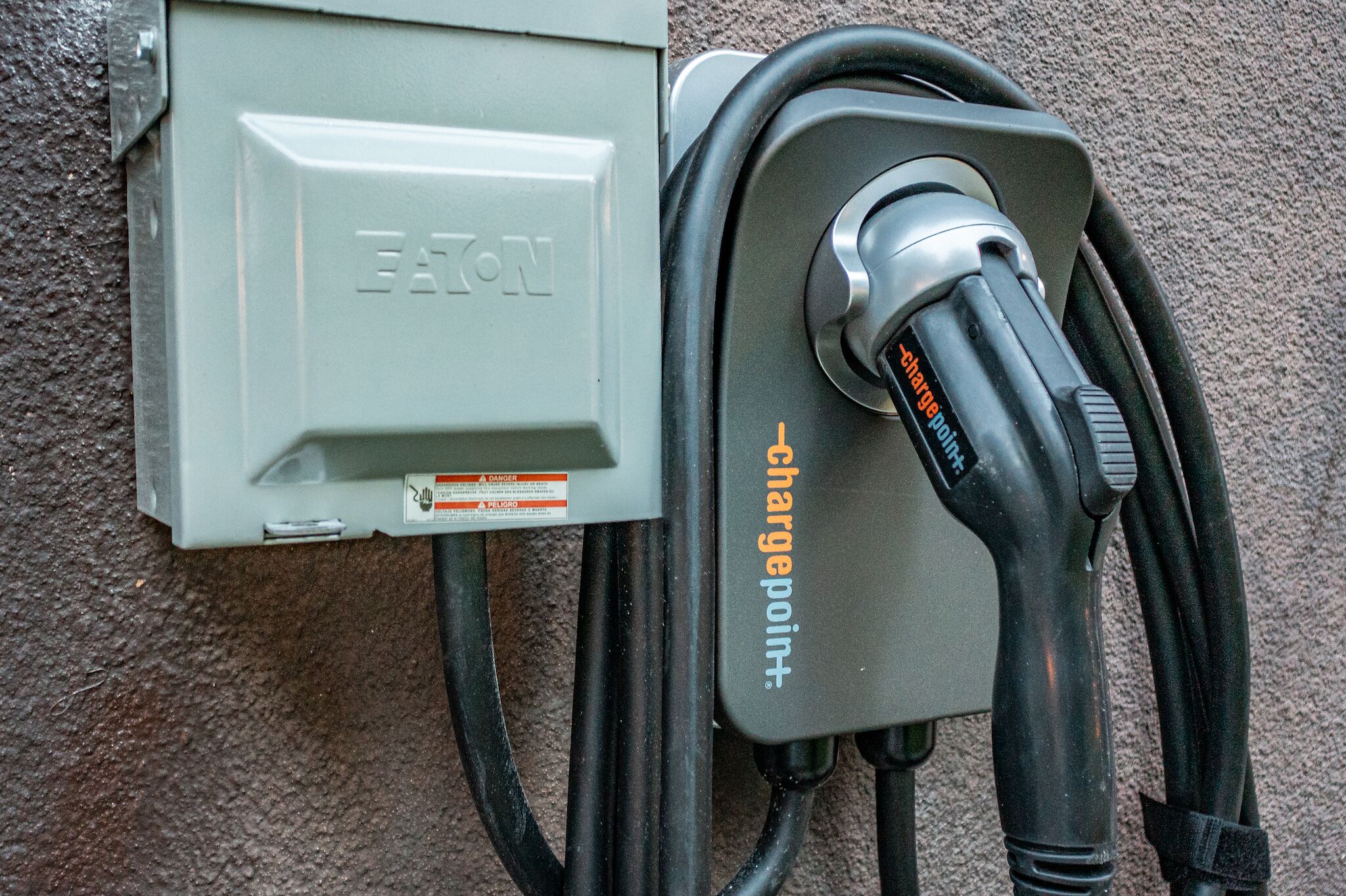A charging station with a cable connected to a gray box labeled "EATON."