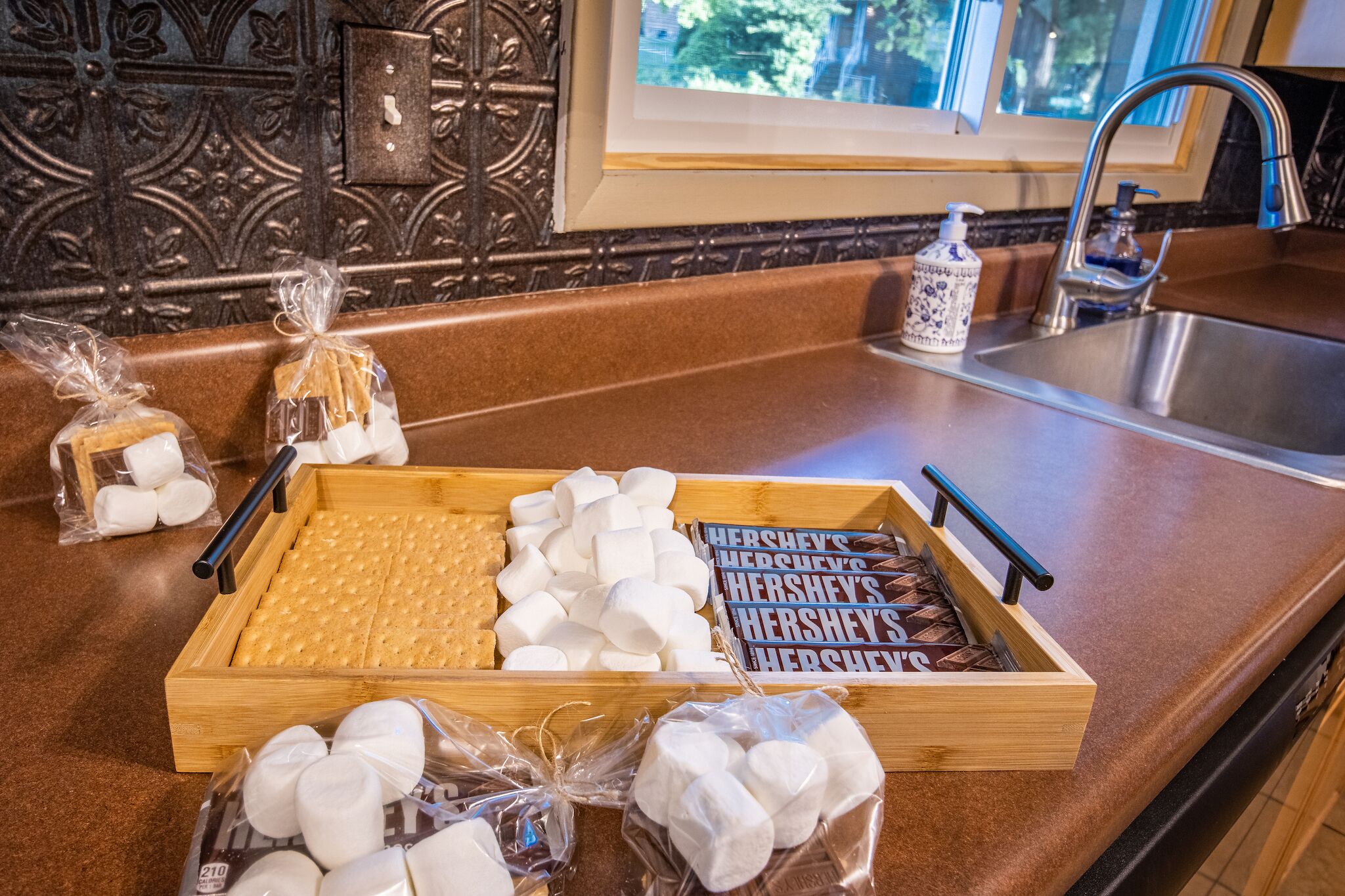 A wooden tray with assorted snacks on a kitchen counter.