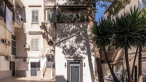 A building with a central entrance, a staircase, and a balcony with plants. - The Quarters Naples Apartment (Naples)