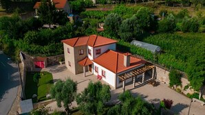 A two-story house with a red roof, a covered patio, and a garden. - Quinta com Piscina Rodeada da Belíssima Paisagem do Alto Minho (Ponte de Lima)