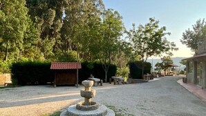 A courtyard with a stone fountain, a wooden structure, and a paved walkway. - Quinta com Piscina Rodeada da Belíssima Paisagem do Alto Minho (Ponte de Lima)