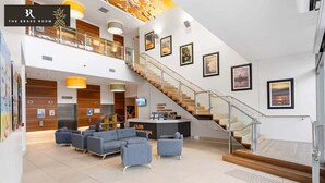 Eine geräumige Lobby mit Treppe, Sitzgelegenheiten und Kunstwerken an den Wänden.