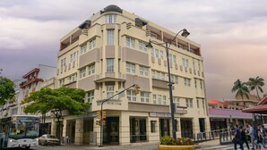 Un hotel de varios pisos con fachada plana, balcones y una entrada central.