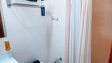 A bathroom with a toilet, sink, and shower.