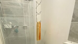 Un baño con cabina de ducha, inodoro y lavabo.