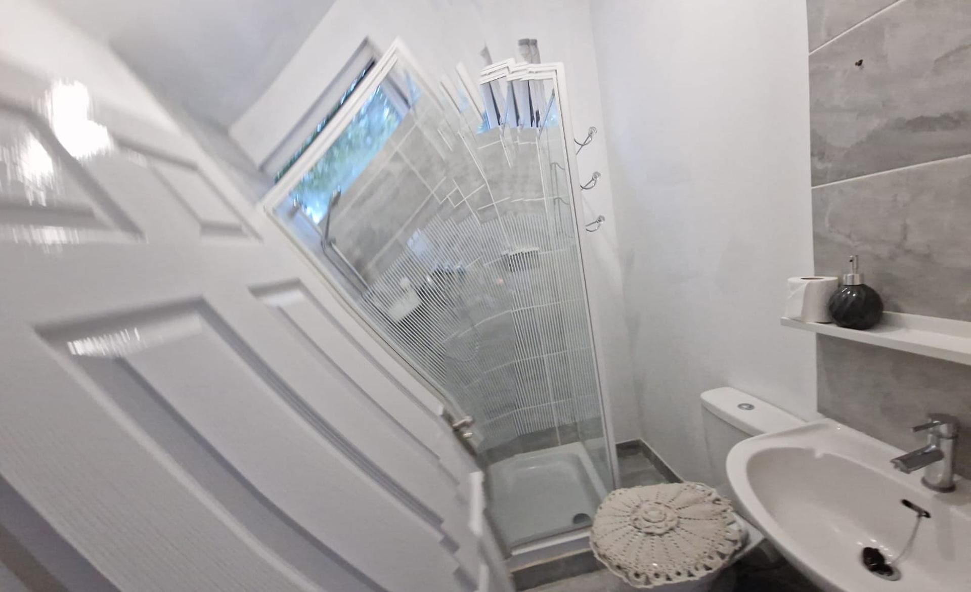 A bathroom with a shower, toilet, and sink.