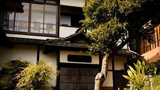 A traditional Japanese house with a wooden gate, stone steps, and a well-maintained garden. - Yamamo Onomichi (Onomichi)