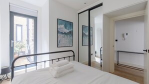 A modern bedroom with a bed, a balcony, and a view of the outside. - Modern 1 Bed | Private Patio | WiFi | East London (London)