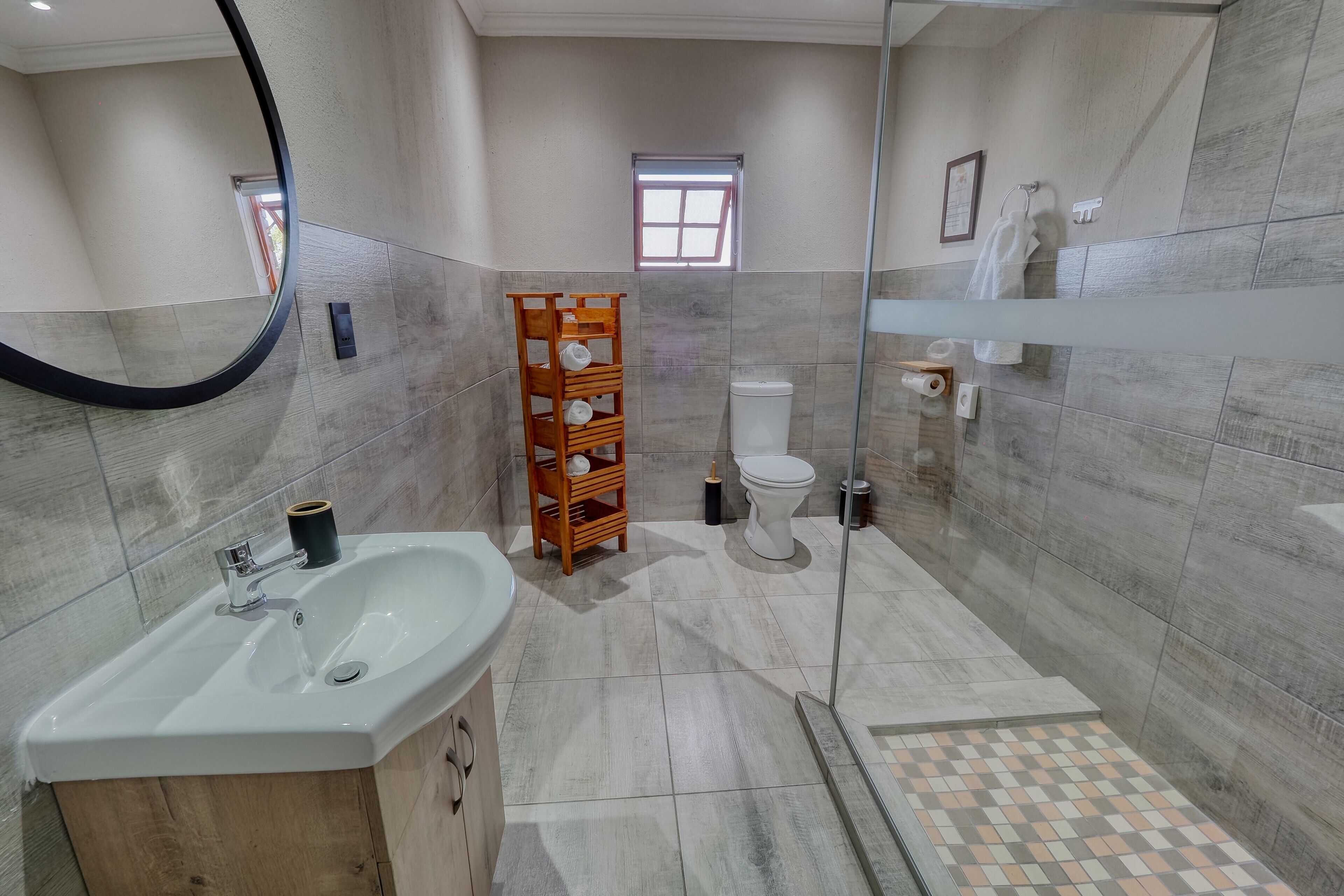 A modern bathroom with a sink, toilet, and shower area.