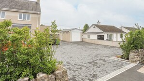 A residential area with houses, a paved driveway, and greenery. - Rhiwlas Bach (Tyn-y-Gongl)