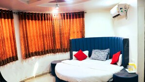A bedroom with a large bed, two bedside tables, a chair, and a ceiling fan.