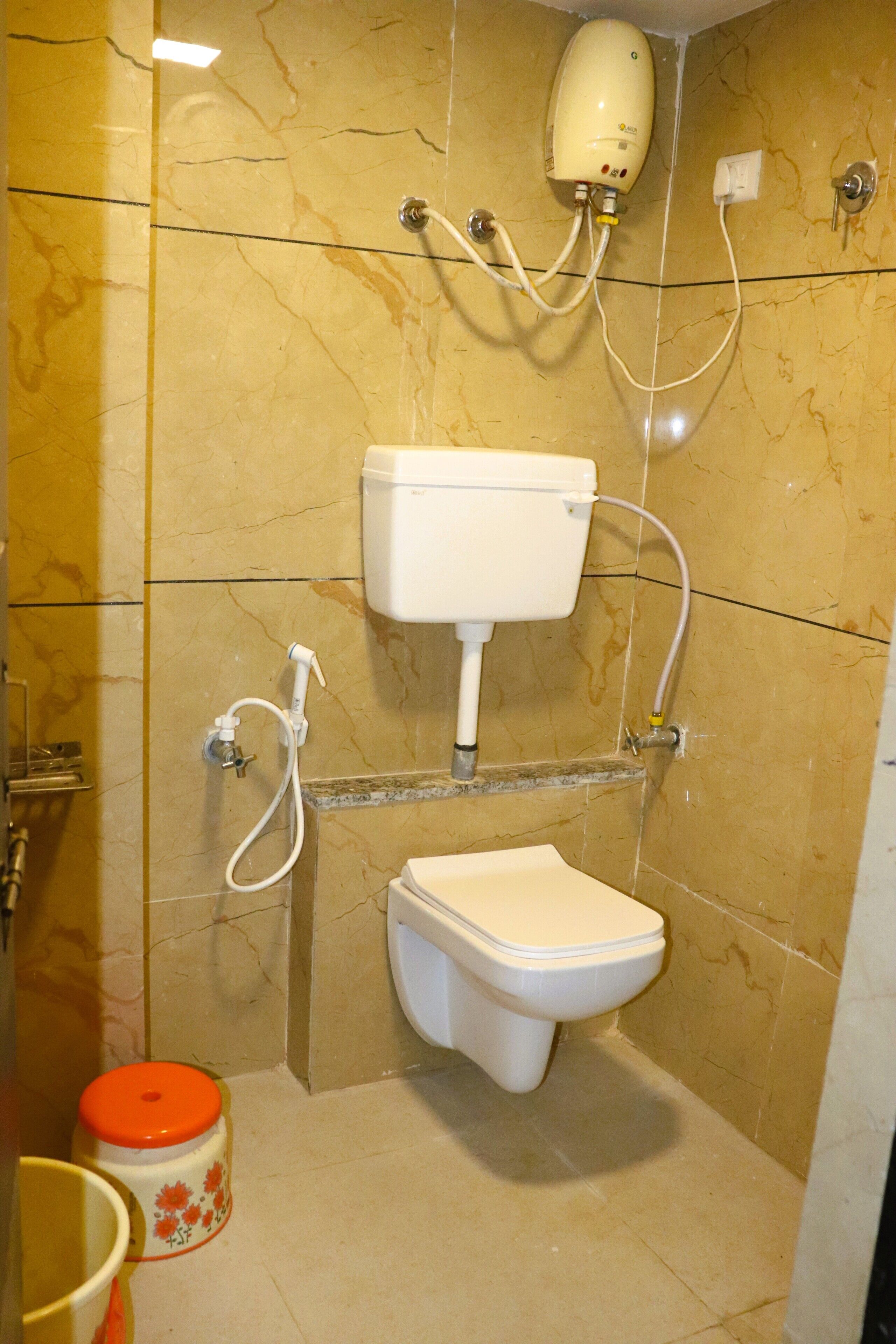 A bathroom with a toilet, a hand dryer, and a sink.