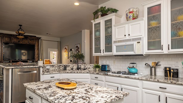 A kitchen with white cabinets, a granite countertop, a built-in dishwasher, and a microwave. - AMAZING Pool home with outdoor kitchen, firepit, and waterfall Close 2 Casinos!  (Bullhead City)