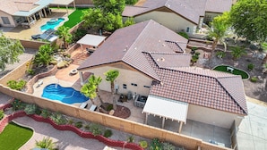 A residential property with a swimming pool, patio, and landscaped garden. - AMAZING Pool home with outdoor kitchen, firepit, and waterfall Close 2 Casinos!  (Bullhead City)
