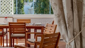 A wooden dining table with four chairs, a pitcher, and a glass on the table. - Sweet Mavy Incantevole Dimora by Wonderful Italy (Olbia)