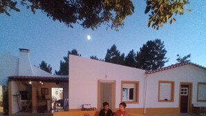 An outdoor seating area with a fire pit, surrounded by a curved stone bench. - O Mundo da Lua Casa Este (São Simão)