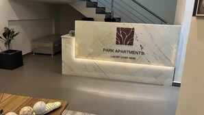 Un mostrador de recepción con encimera de mármol y un logotipo que dice "PARK APARTMENTS. LUXURY LIVES HERE".