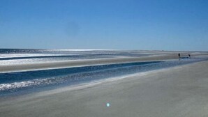 Una spiaggia con cielo sereno e il sole splendente.