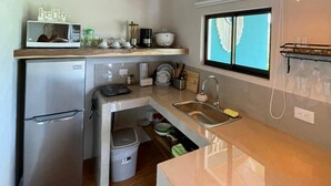 A compact kitchen with wooden ceiling, stainless steel appliances, and pendant lighting. - Villa Luna del Arenal (La Fortuna)
