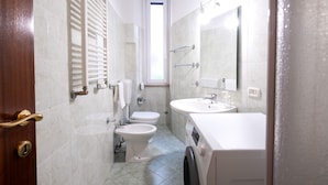 A compact bathroom with a toilet, bidet, and a sink. - Casa Riboty - One Bedroom Apartment, Sleeps 2 (Rome)