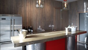 A kitchen with wooden walls, stainless steel appliances, and hanging light fixtures. - Oliver Oasis, Merlot - Vineyard home with great pool, hot tub & views for days!  (Osoyoos)