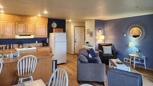 A compact living space with a kitchen, dining area, and seating area. - Windsong # 6 Beautiful condo with partial ocean view (Ocean Shores)
