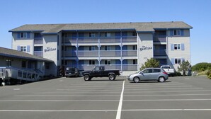 A multi-story motel with balconies and a parking lot. - Nautilus # 202 - Ocean Front Condos (Ocean Shores)