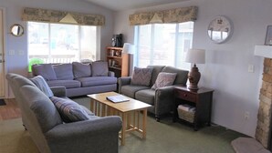 A living room with two sofas, a small table, a lamp, and a bookshelf.