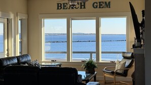 Un salon avec vue sur la plage et l’océan.