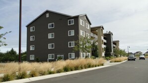 A multi-story residential building with a flat roof, multiple windows, and a parking lot in front. - Outlook 309/Oyhut Bay (Ocean Shores)