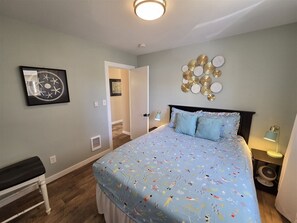 A bedroom with a bed, a bench, a wall art piece, and a decorative wall hanging. - Sea Angel - Stunning views from this ocean front home ! (Moclips)
