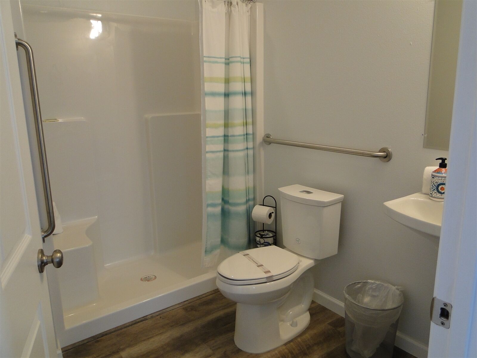 Een badkamer met een inloopdouche, toilet, bidet en handdroger.