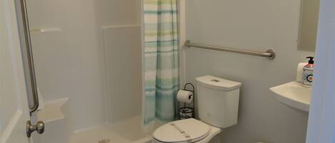 Een badkamer met een inloopdouche, toilet, bidet en handdroger.