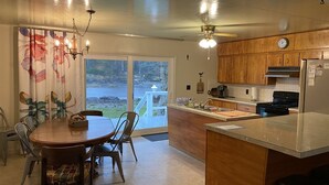 A modern kitchen with wooden cabinets, a built-in stove, and a large island. - Joe Creek Inn- Unique Home (Pacific Beach)