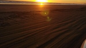 Ein Strand bei Sonnenuntergang, der klare Himmel.