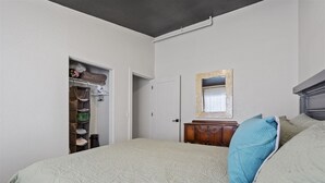 Un dormitorio con cama, cómoda, espejo y armario.