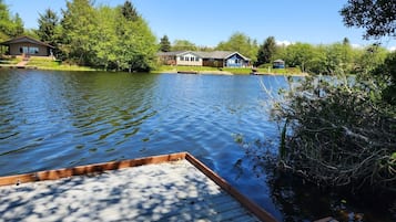 Enjoy a serene lakeside retreat with a tranquil dock and lush green surroundings.