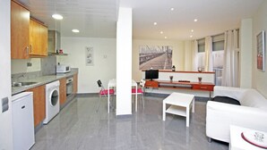 A compact living space with a kitchen, dining area, and a sofa. - BeBarceloner Studios minutes from Pl Universidad (Barcelona)