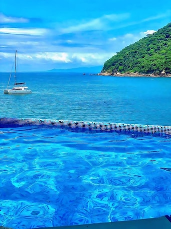 Una piscina al aire libre, sillones reclinables de piscina