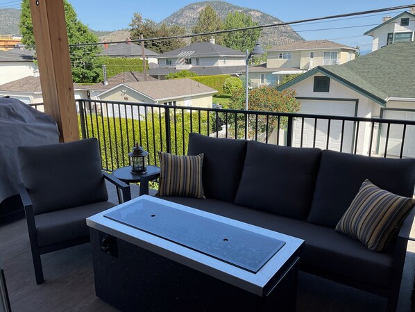 A balcony with a sofa, a small table, and a lantern.