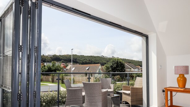 Ein Balkon mit Korbmöbeln und Blick auf Häuser.