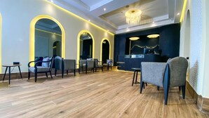 A modern hotel lobby with wooden flooring, seating areas, and a reception desk. - Ennasma (Casablanca)