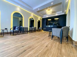 Un moderno vestíbulo de hotel con pisos de madera, zonas de estar y una recepción.