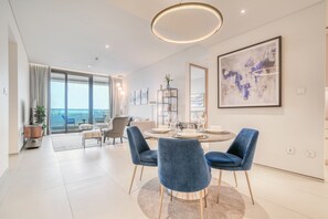 Un comedor moderno con una mesa redonda, sillas azules y vistas a la ciudad.